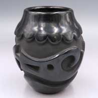 A black jar with an avanyu design carved around its belly