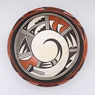 A polychrome bowl with a bird element and geometric design inside and a bird element and geometric design around the shoulder of the bowl