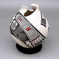 A polychrome jar with an organic cut opening and decorated with a geometric design