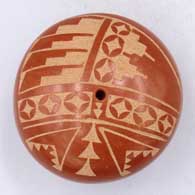 A red seed pot decorated with a sgraffito geometric design