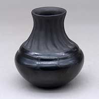 A small black jar with an extended, fluted, matte neck