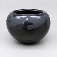 A small black-on-black bowl decorated above the shoulder with a geometric design