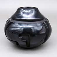 A black jar with a carved kiva step and geometric design