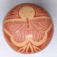 A miniature polychrome seed pot with decorated with a sgraffito butterfly, scroll and geometric design