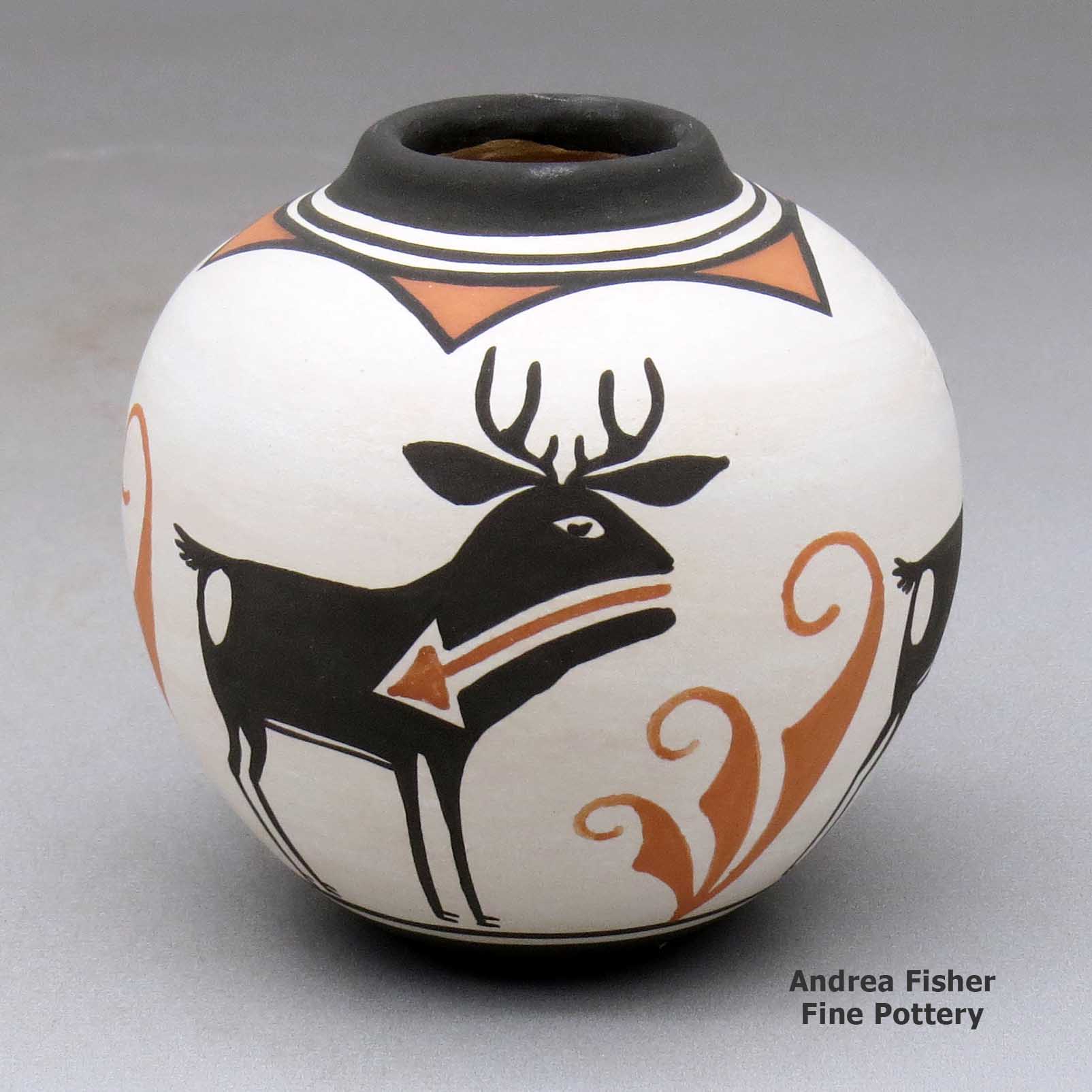 Click or tap to see a larger view A small polychrome jar with a raised rim and a four panel deer with heart line and geometric design made by Carlos Laate of Zuni