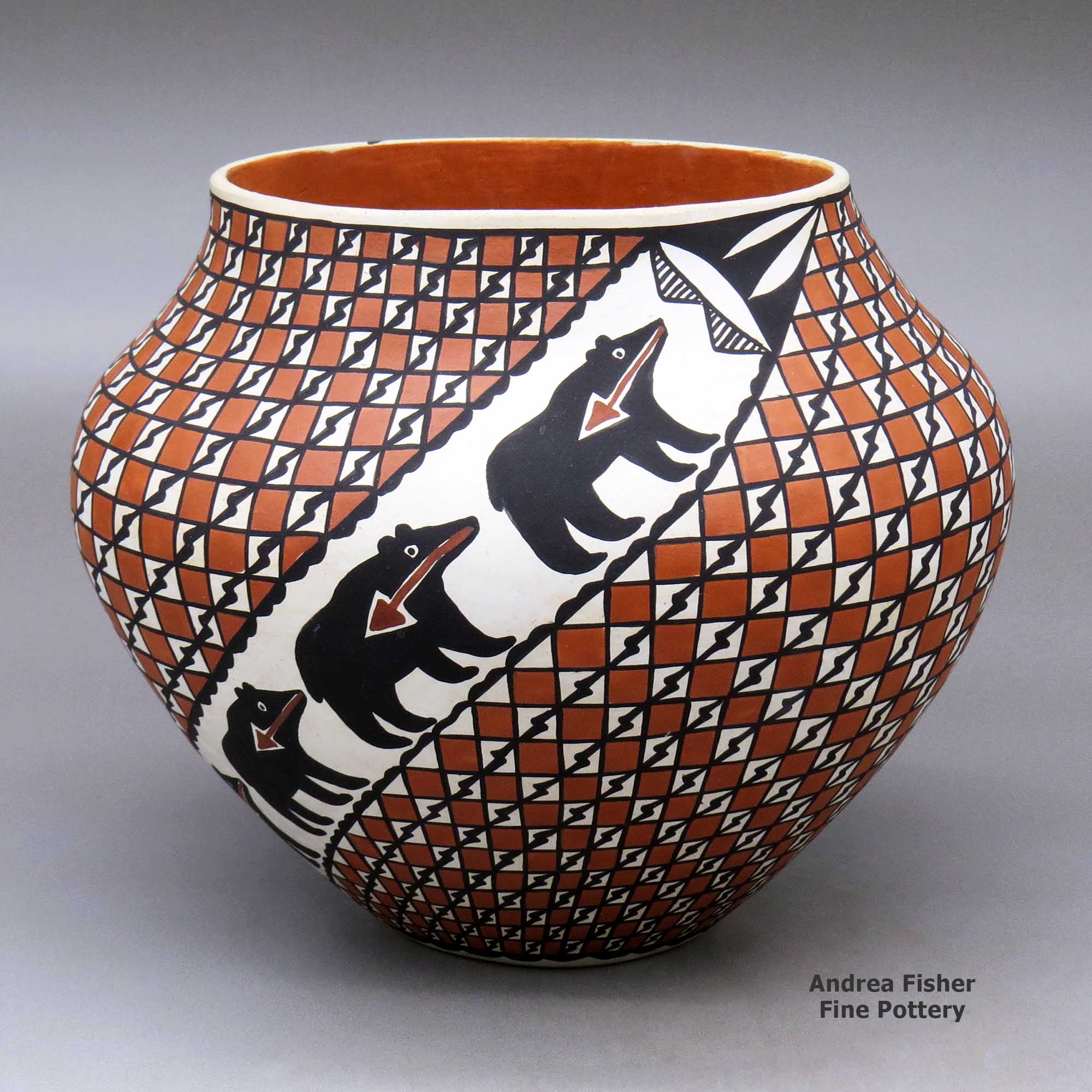 Click or tap to see a larger view A polychrome jar decorated with two spiral bands of animals with heart line separated by fields of checkerboard and geometric design made by Mildred Antonio of Acoma