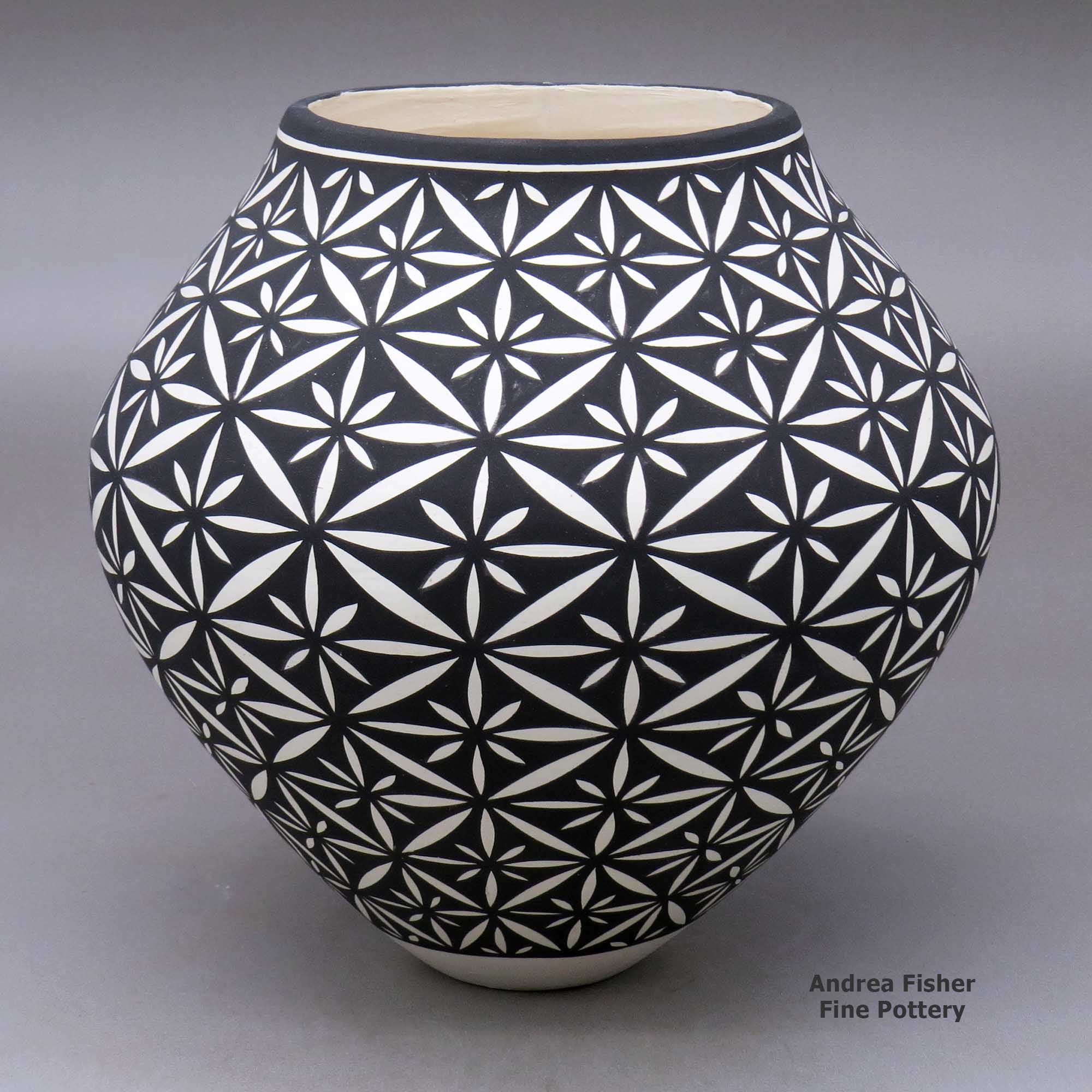 Click or tap to see a larger view A black on white jar decorated with a yucca-leaf snowflake geometric design made by Katherine Victorino of Acoma