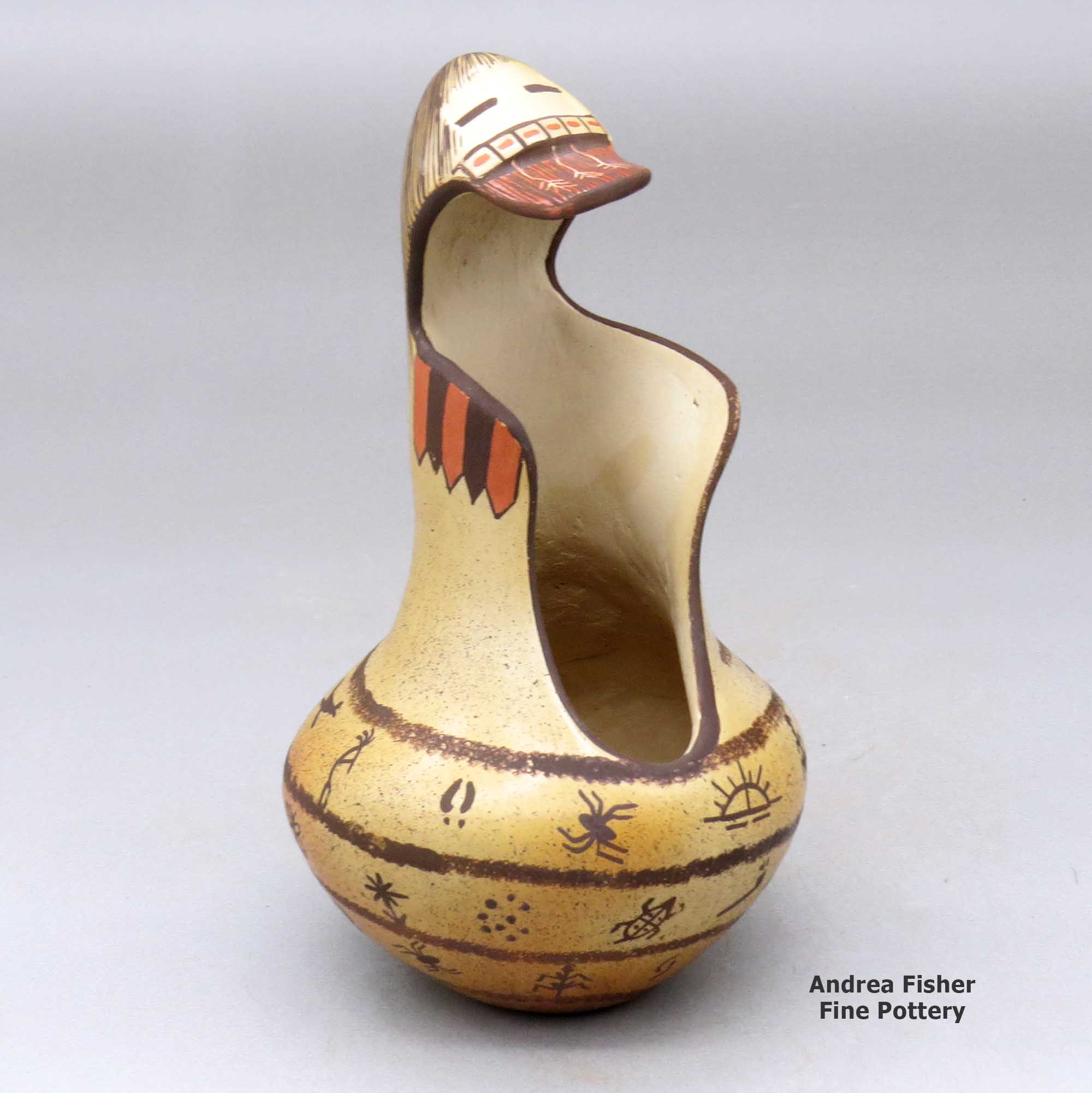 Click or tap to see a larger view A polychrome jar with a kachina mask overlay and decorated with a rock art, bird element and geometric design made by Garrett Maho of Hopi