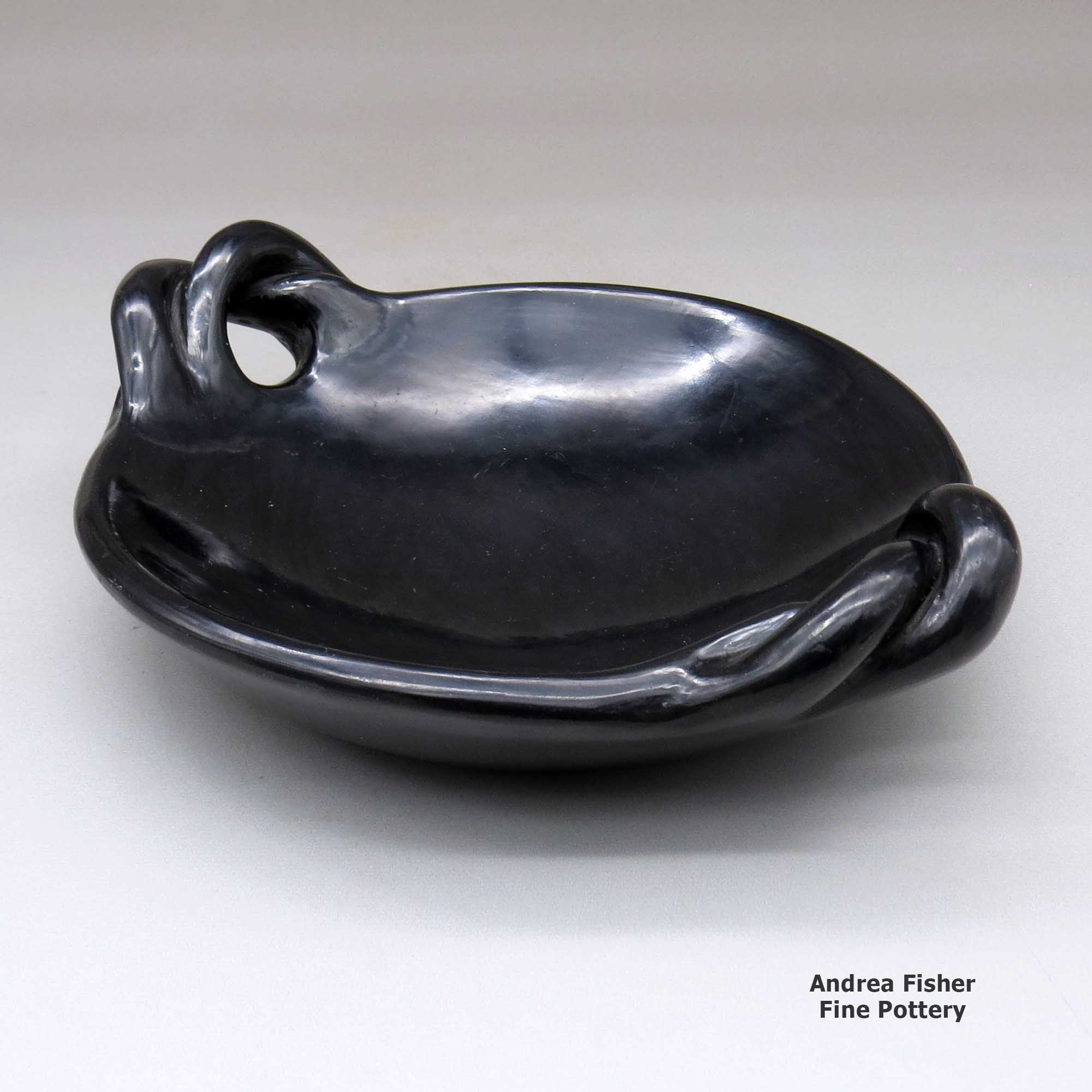 Click or tap to see a larger view A polished black serving plate with twisted handles made by Teresita Naranjo of Santa Clara