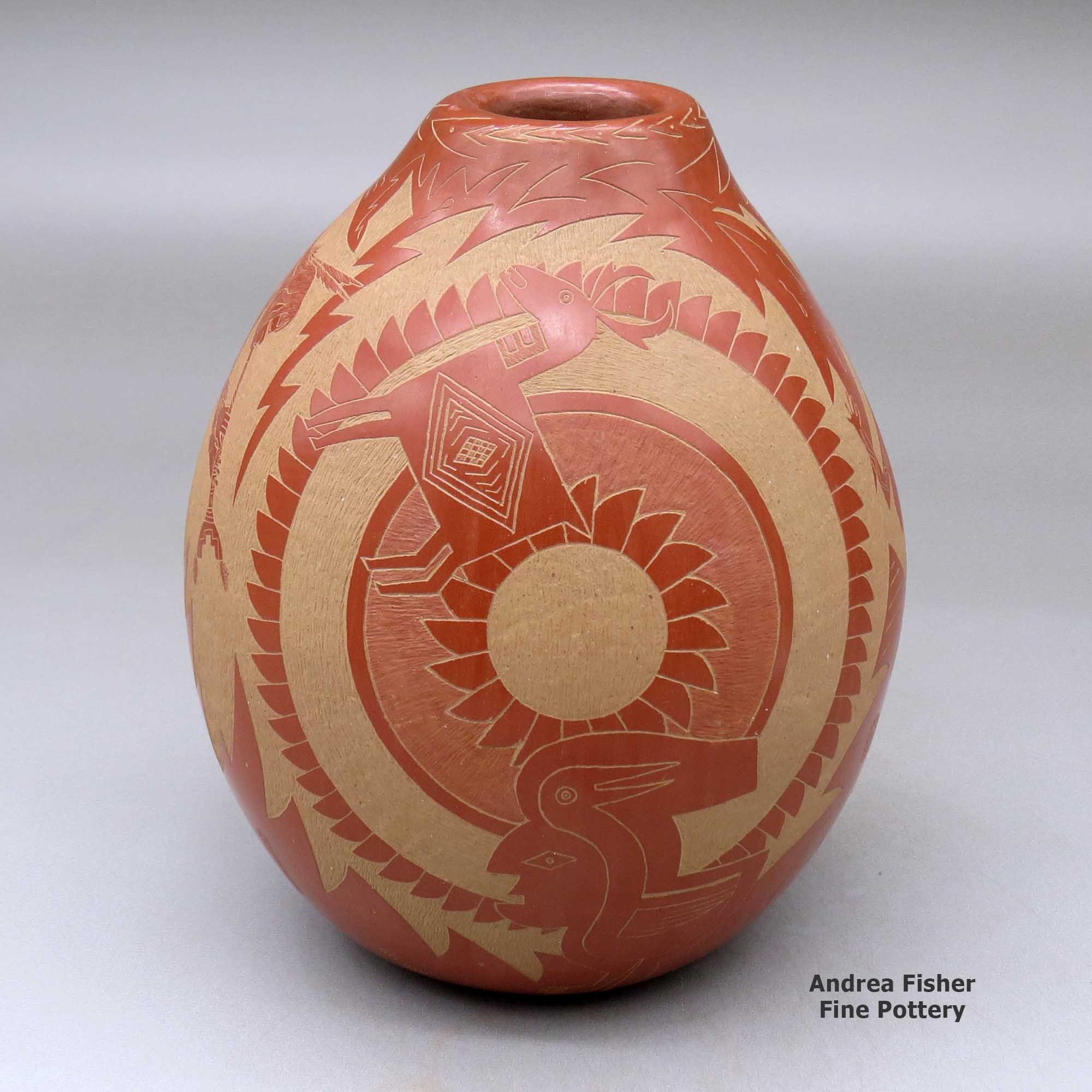 A red jar decorated with a sgraffito design incorporating several Mimbres figures, warriors and geometric designs made by Roy Tanner of Santa Clara