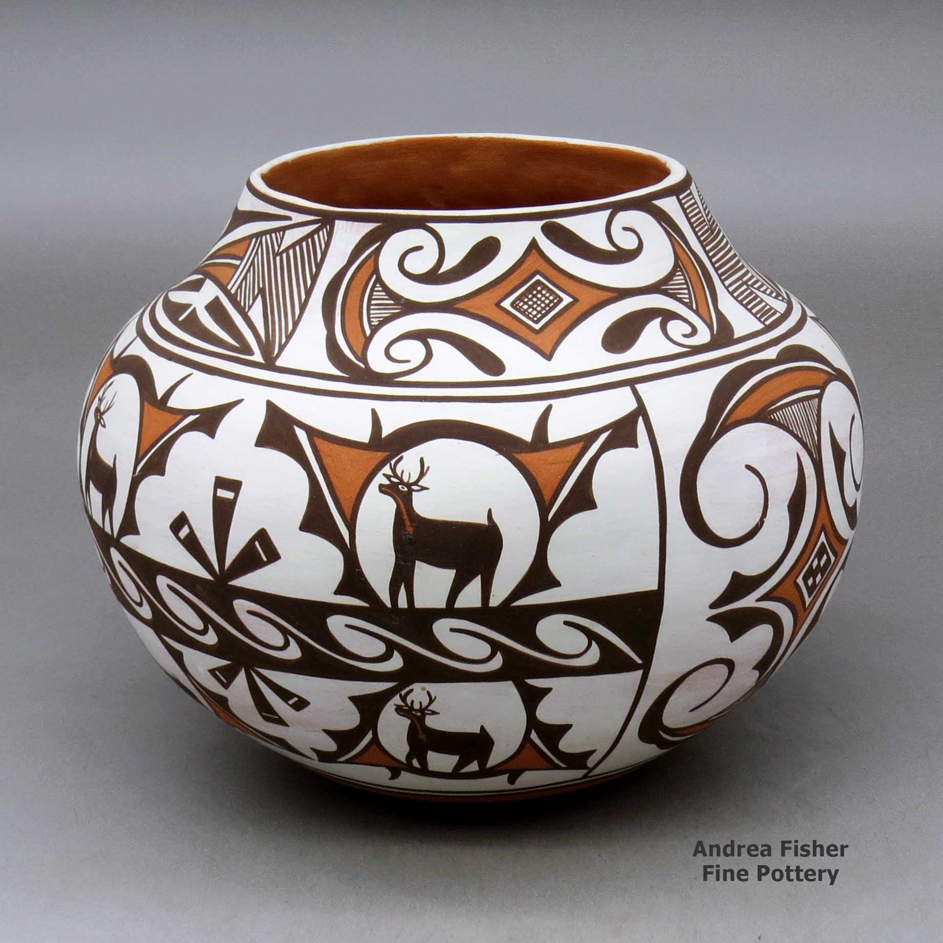 Click or tap to see a larger view A polychrome jar decorated with a four panel deer in his house, rainbird, fineline and geometric design made by Noreen Simplicio of Zuni