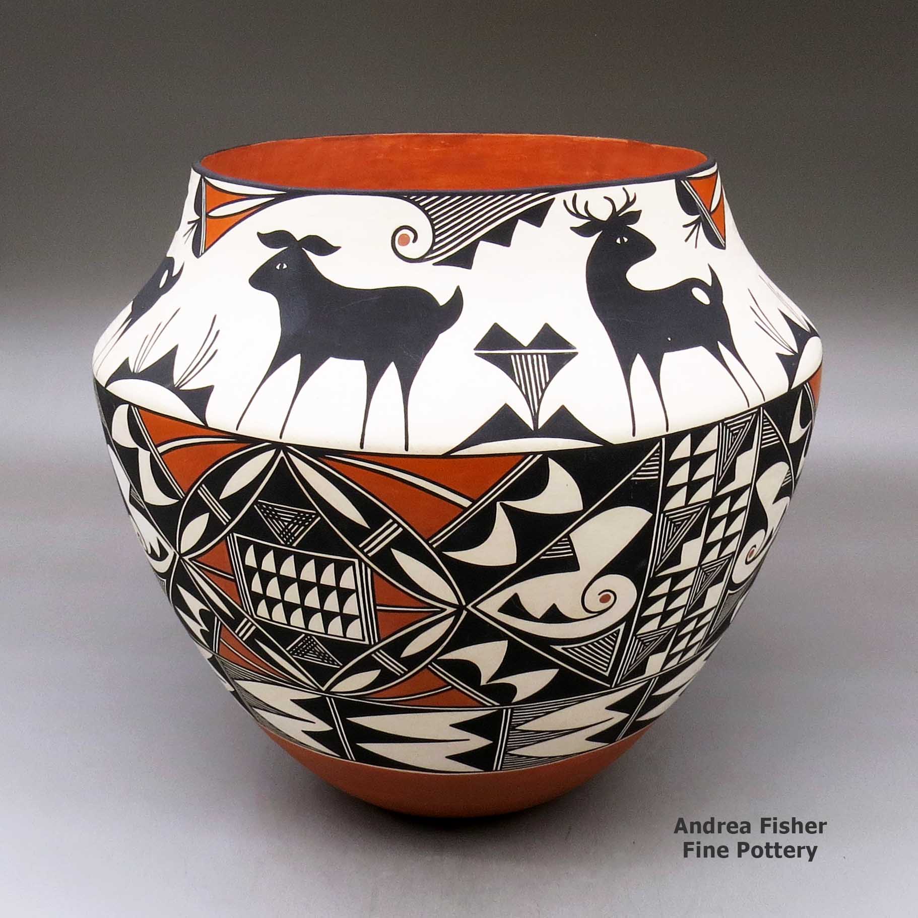 Click or tap to see a larger view A large polychrome jar decorated with a three panel geometric design below the shoulder and a six panel deer and geometric design above the shoulder made by Goldie Hayah of Acoma
