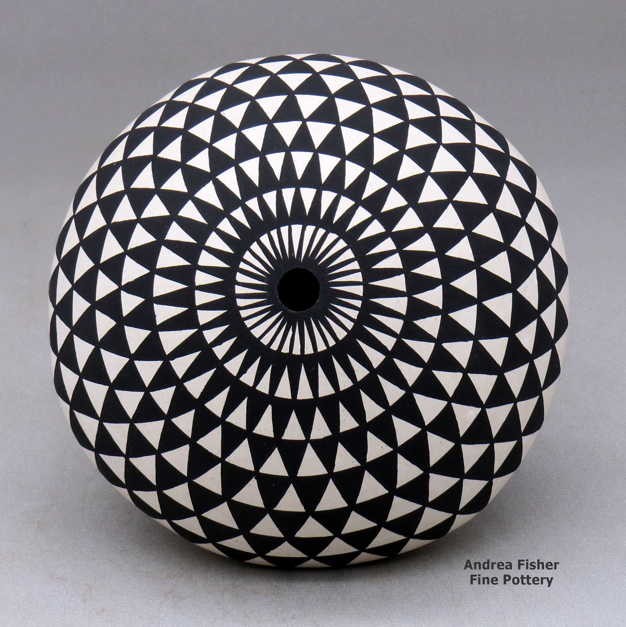 Click or tap to see a larger view A black on white seed pot with legs and decorated with a geometric design above the shoulder made by Yolanda Trujillo of Acoma