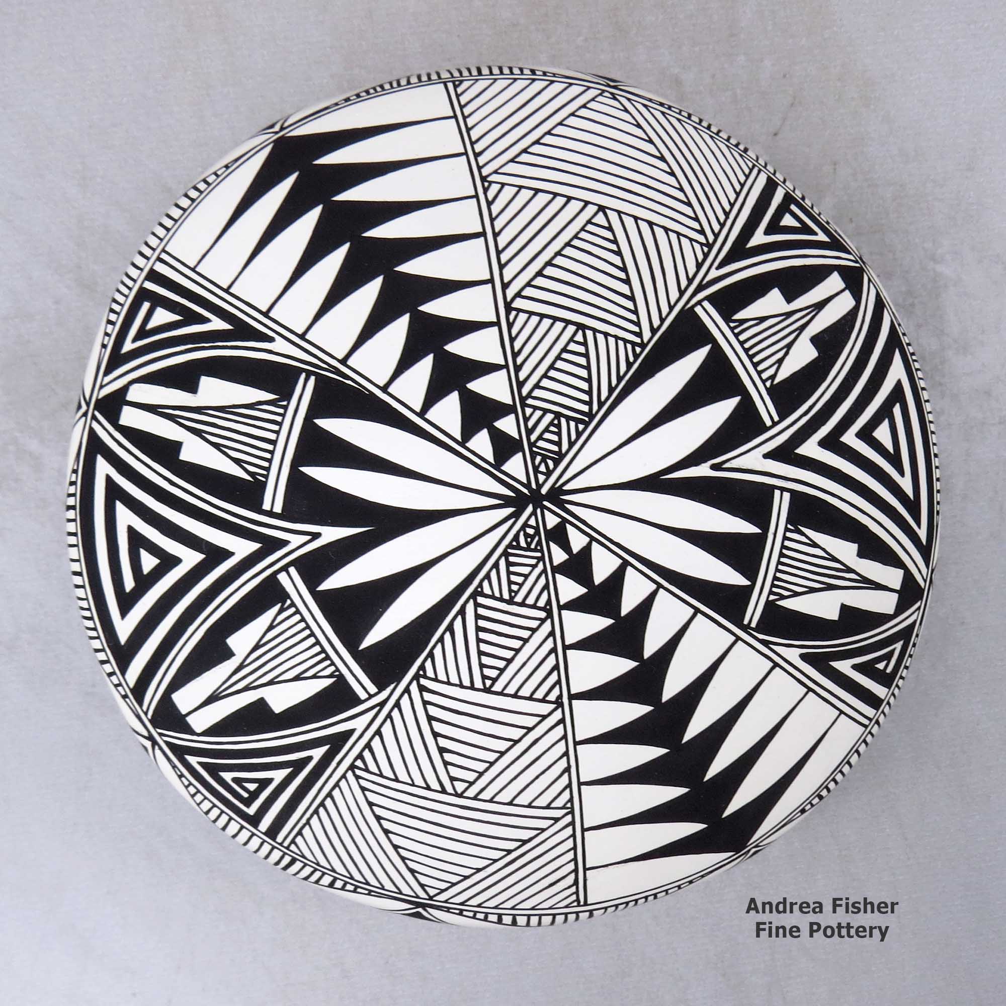 Click or tap to see a larger view A black on white seed pot decorated with a yucca-leaf snowflake, fineline and geometric design made by Cletus Victorino of Acoma