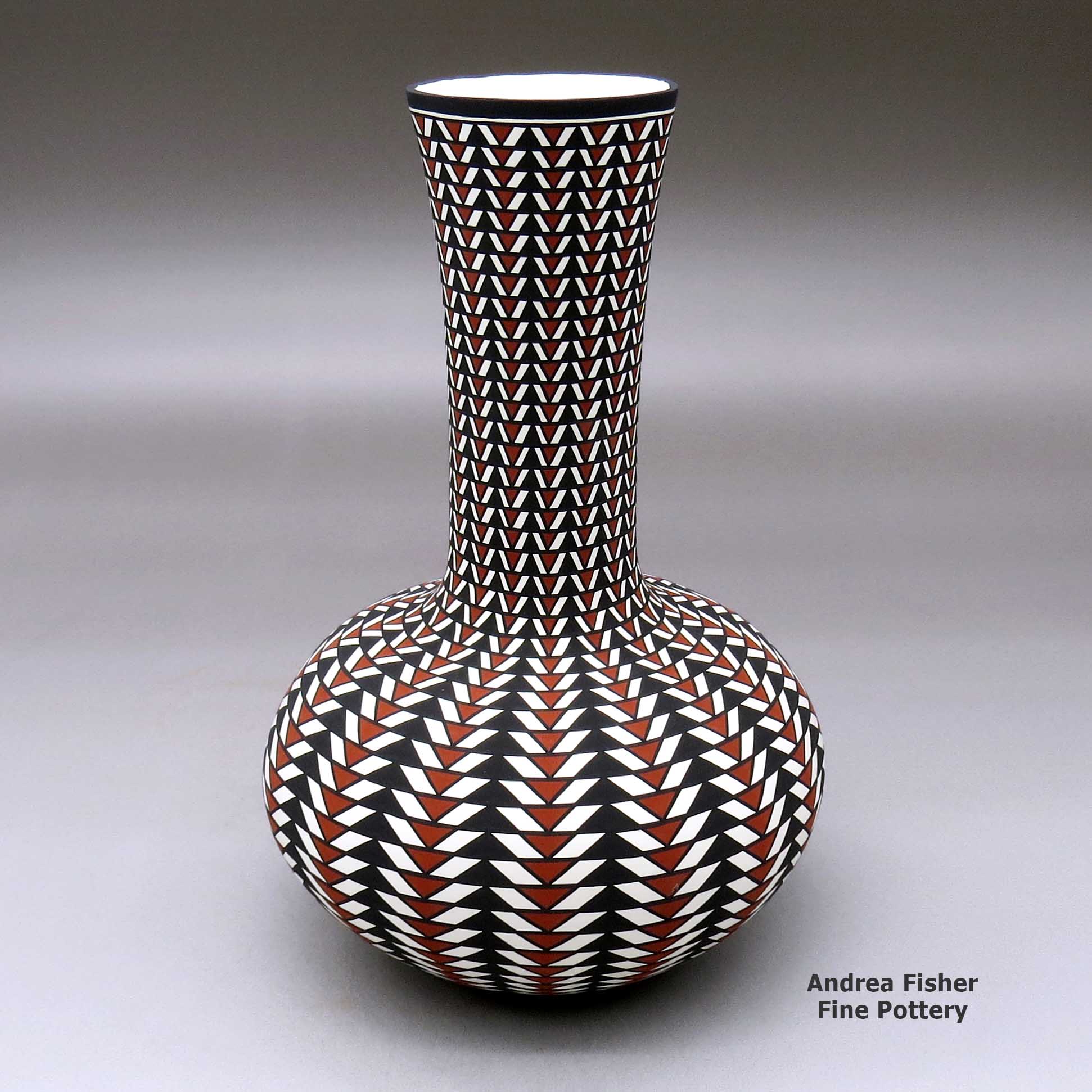 Click or tap to see a larger view A tall neck polychrome vase decorated with a geometric design made by Paula Estevan of Acoma