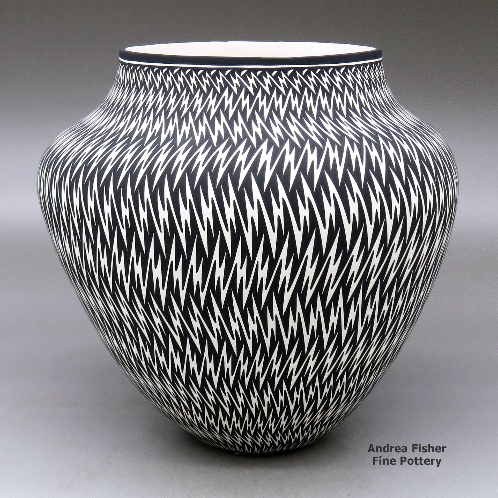 Click or tap to see a larger view A black on white jar decorated with a lightning bolt geometric design made by Paula Estevan of Acoma