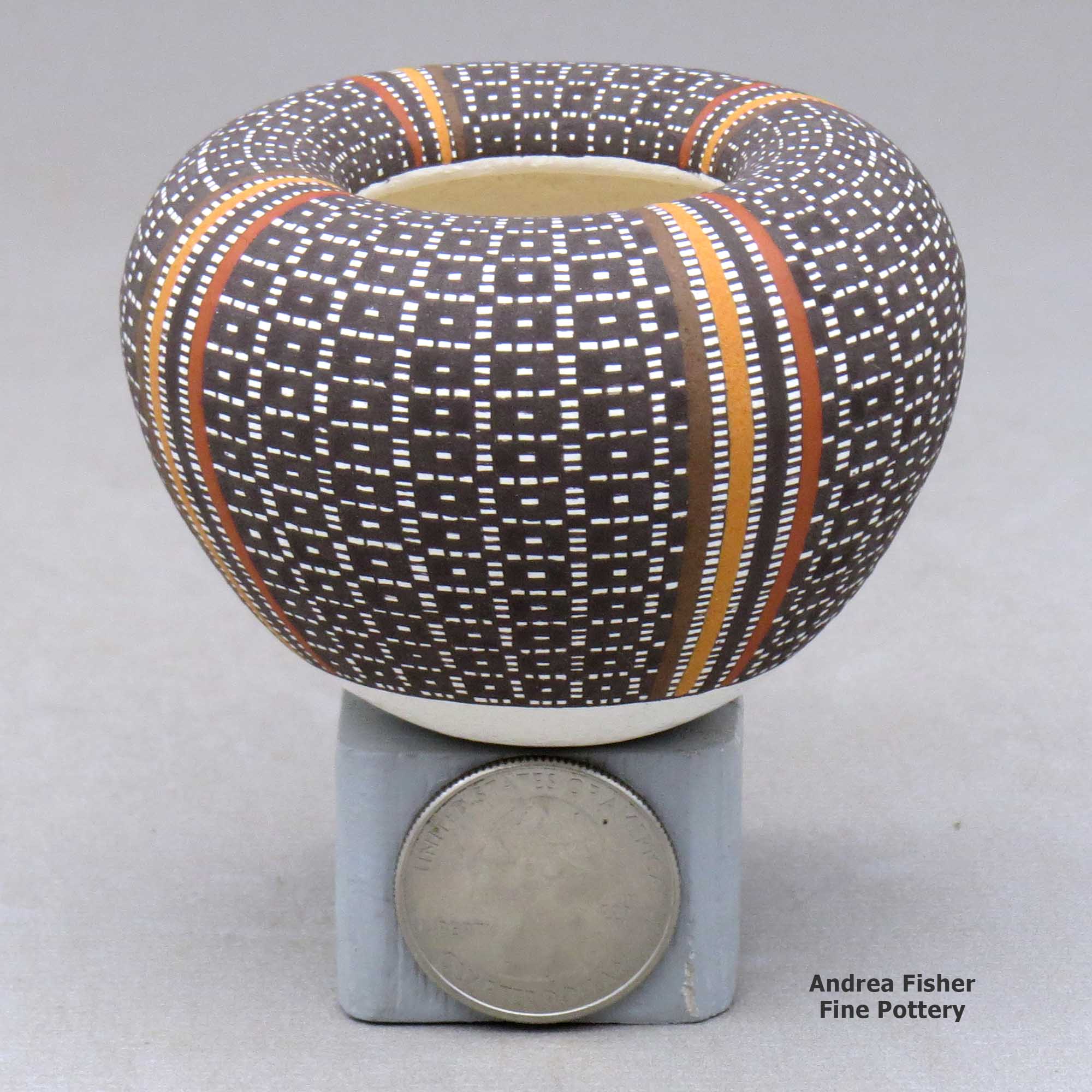 Click or tap to see a larger view A miniature polychrome jar with an Infinity rim and decorated with a four-panel tiny-square geometric design made by Frederica Antonio of Acoma