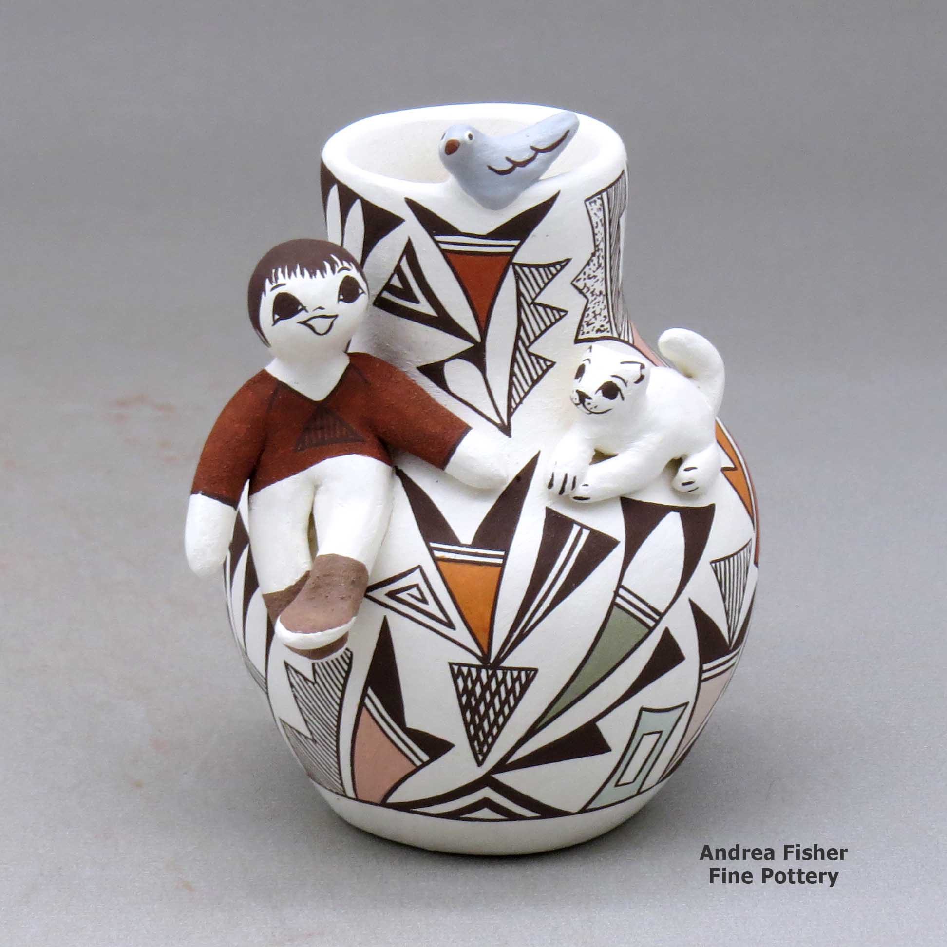 Click or tap to see a larger view A small polychrome jar with a boy and cat perched on the shoulder and a bird on the rim and decorated with a lizard and geometric design made by Judy Lewis of Acoma