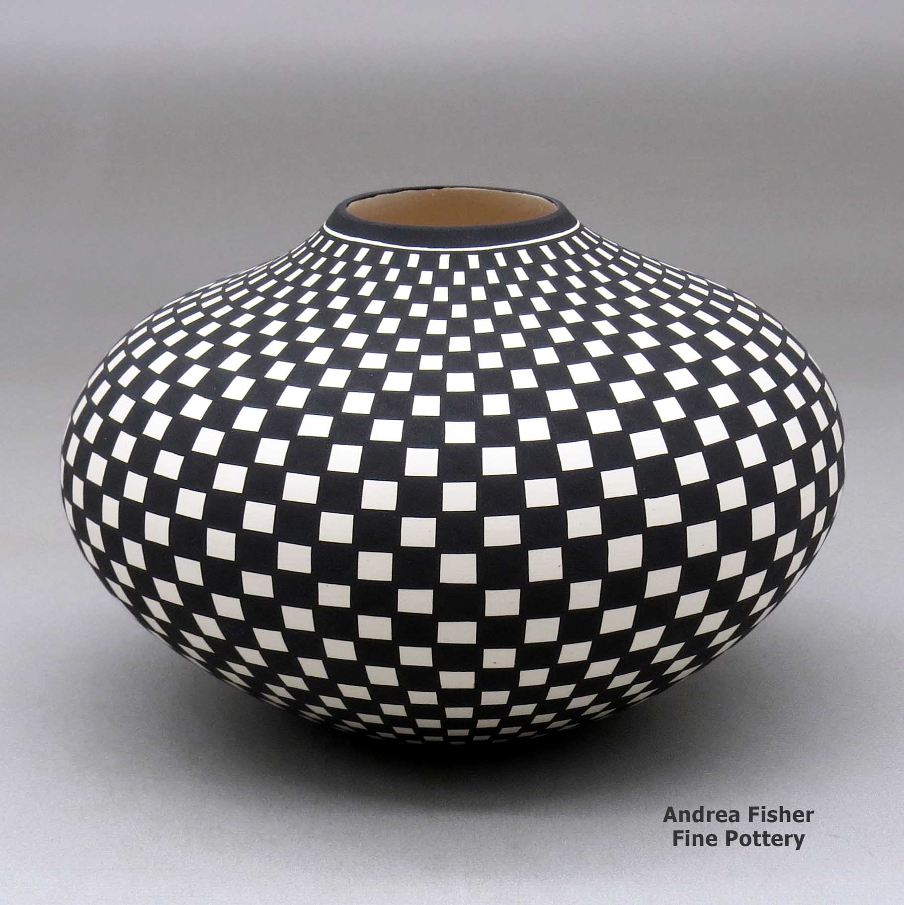 Click or tap to see a larger view A black on white jar decorated with a checkerboard geometric design made by Paula Estevan of Acoma