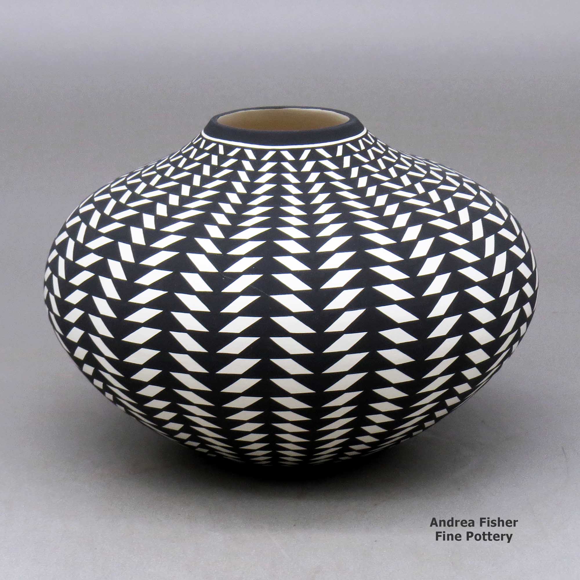 Click or tap to see a larger view A black on white jar decorated with a basket weave geometric design made by Paula Estevan of Acoma