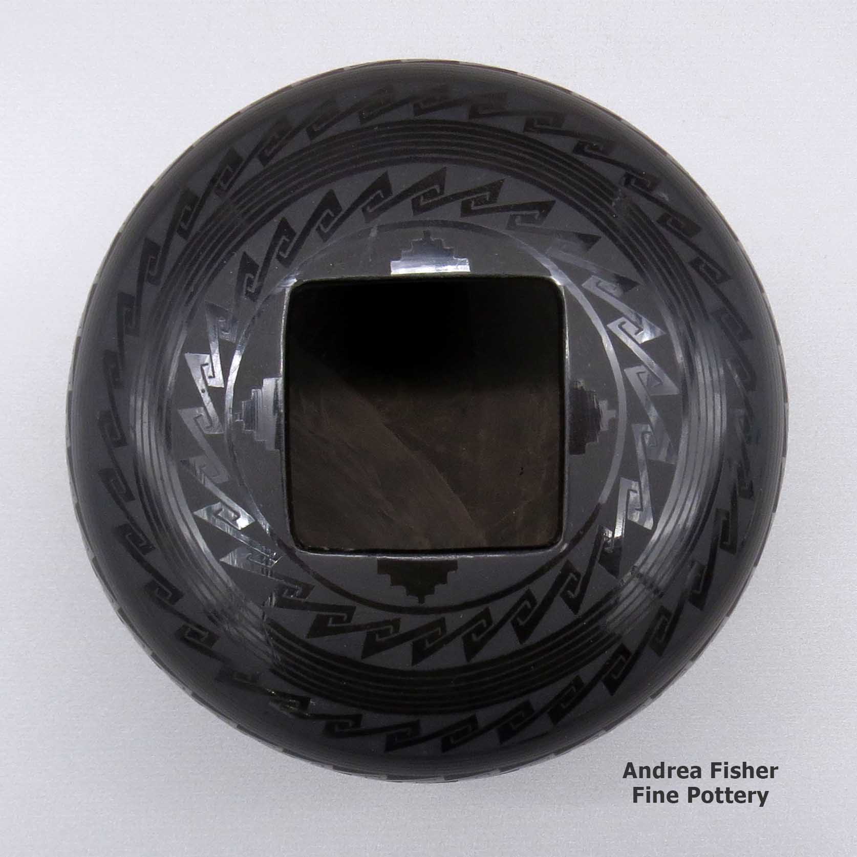 Click or tap to see a larger view A black on black jar with a square geometric cut opening and a geometric design made by Ruben Rodriguez of Mata Ortiz and Casas Grandes