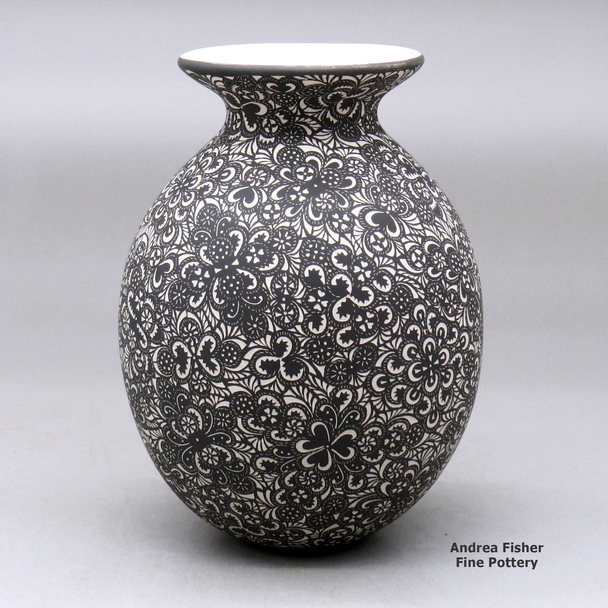 Click or tap to see a larger view A black on white jar with a flared rim and decorated with a sgraffito geometric design made by Hector Javier Martinez of Mata Ortiz and Casas Grandes
