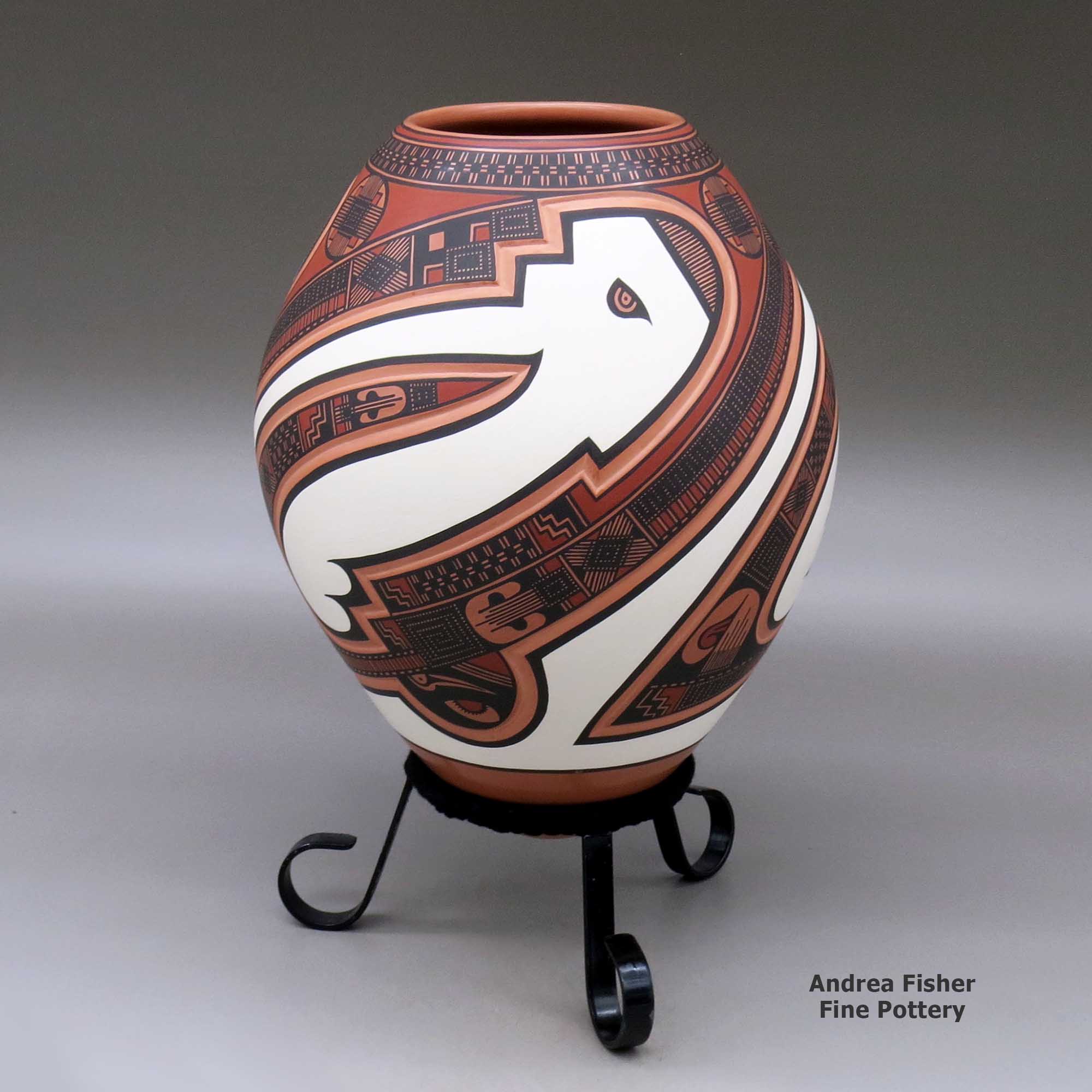 Click or tap to see a larger view A polychrome jar decorated with a three panel lightly carved and painted sickle, bird element and geometric design made by Tavo Silveira of Mata Ortiz and Casas Grandes