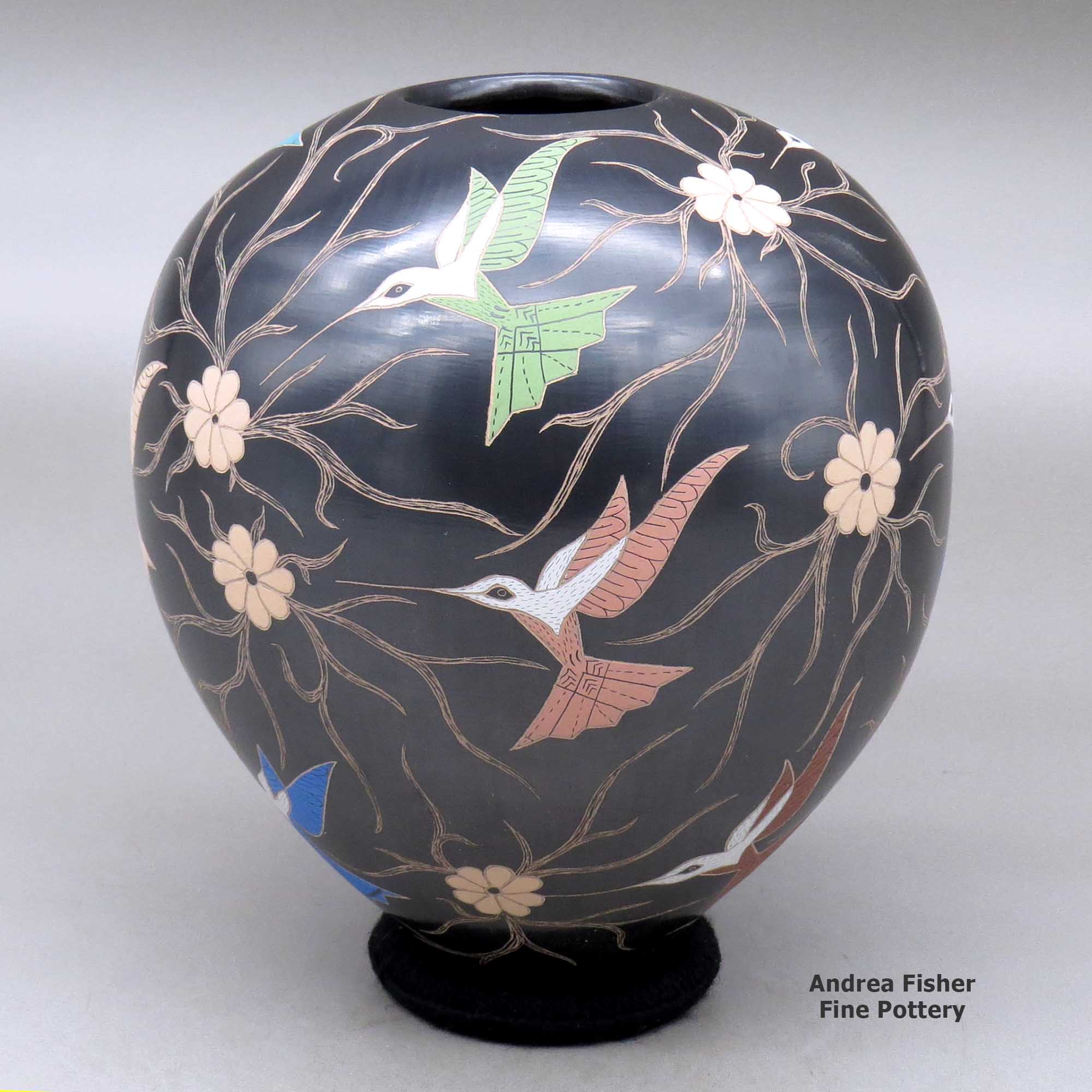 Click or tap to see a larger view A polychrome jar decorated with a sgraffito and painted hummingbird, flower and vine design made by Elicena Cota of Mata Ortiz and Casas Grandes
