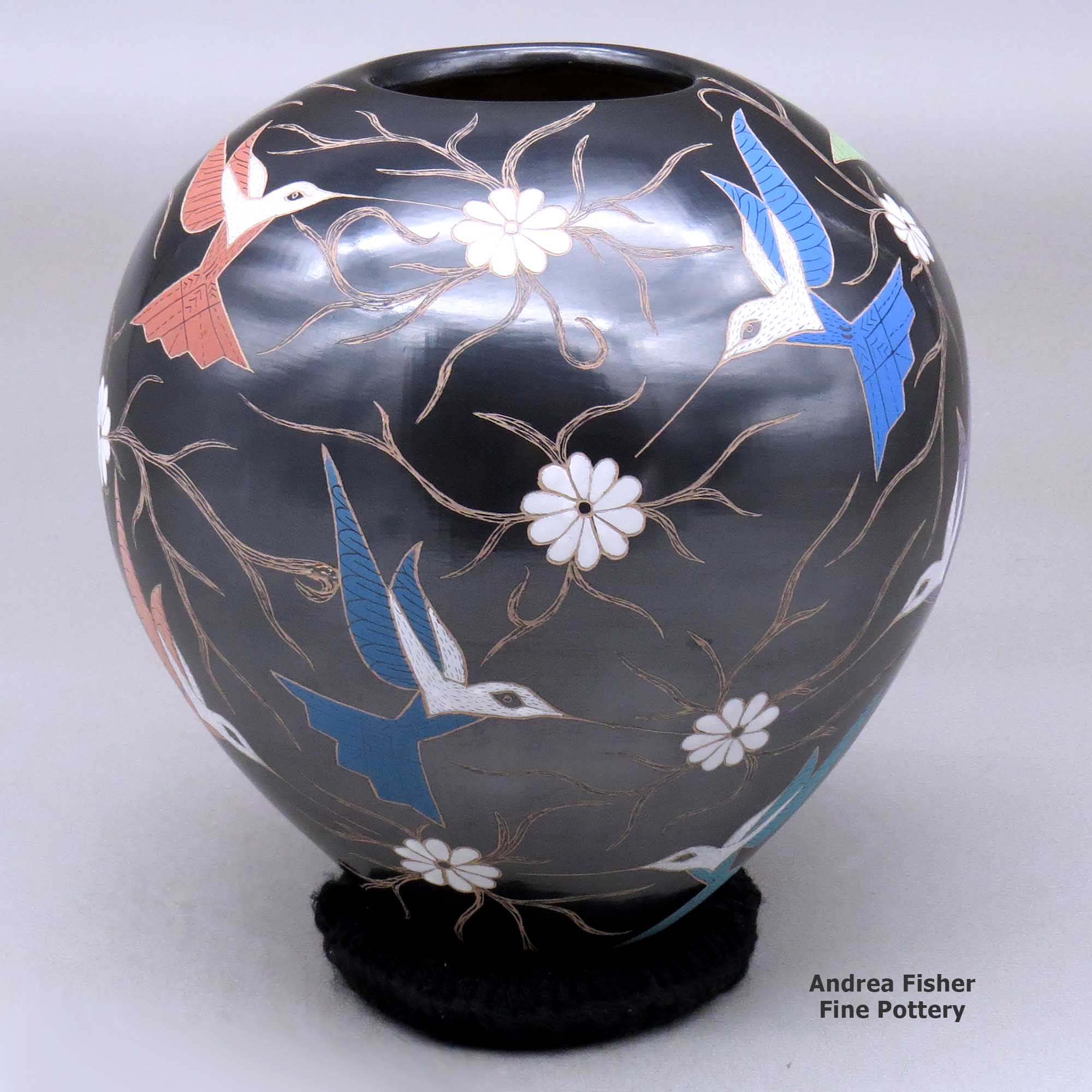 Click or tap to see a larger view A polychrome jar decorated with a sgraffito and painted hummingbird, vine and flower design made by Elicena Cota of Mata Ortiz and Casas Grandes