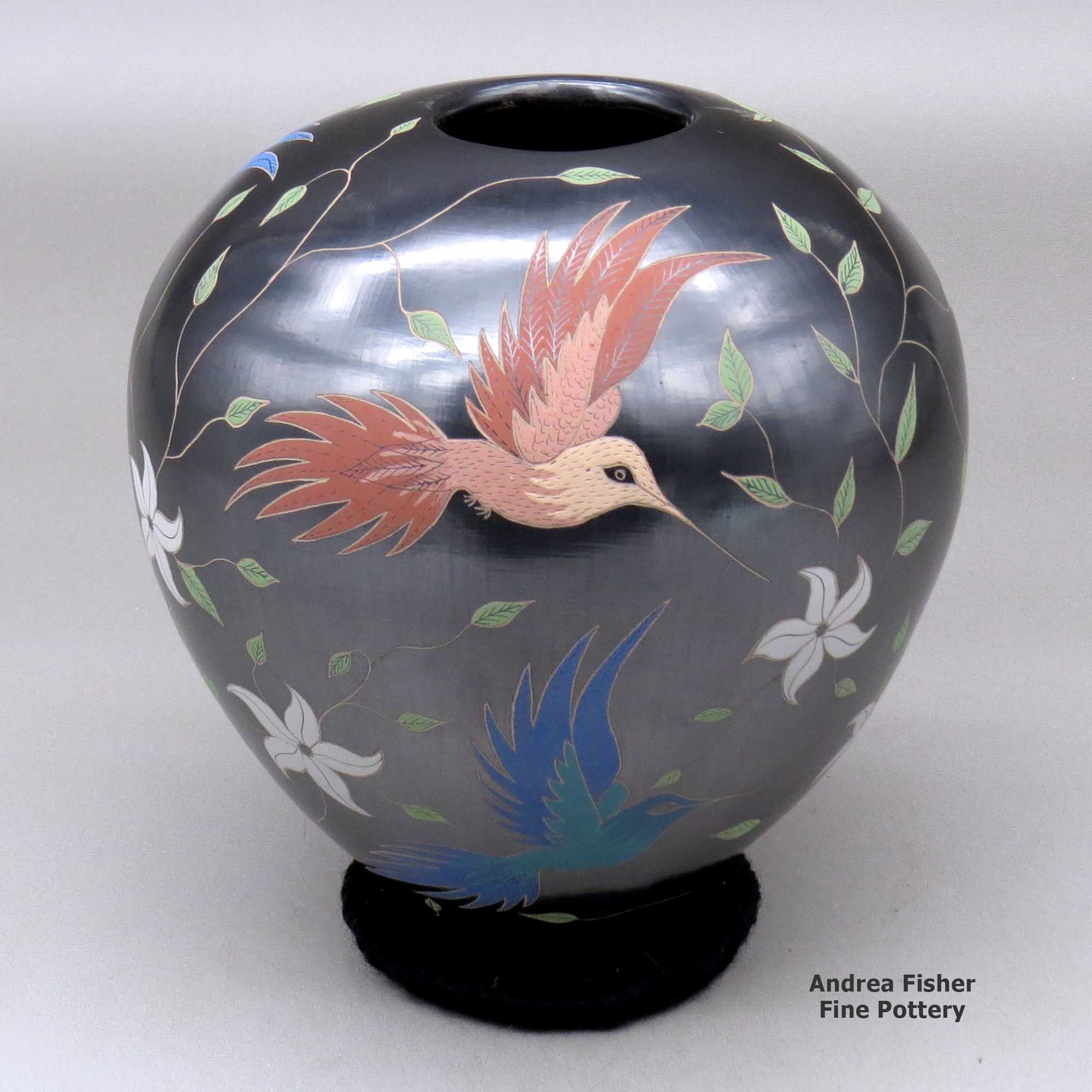 Click or tap to see a larger view A polychrome jar decorated with a bird, branch, flower and leaf design made by Elicena Cota of Mata Ortiz and Casas Grandes