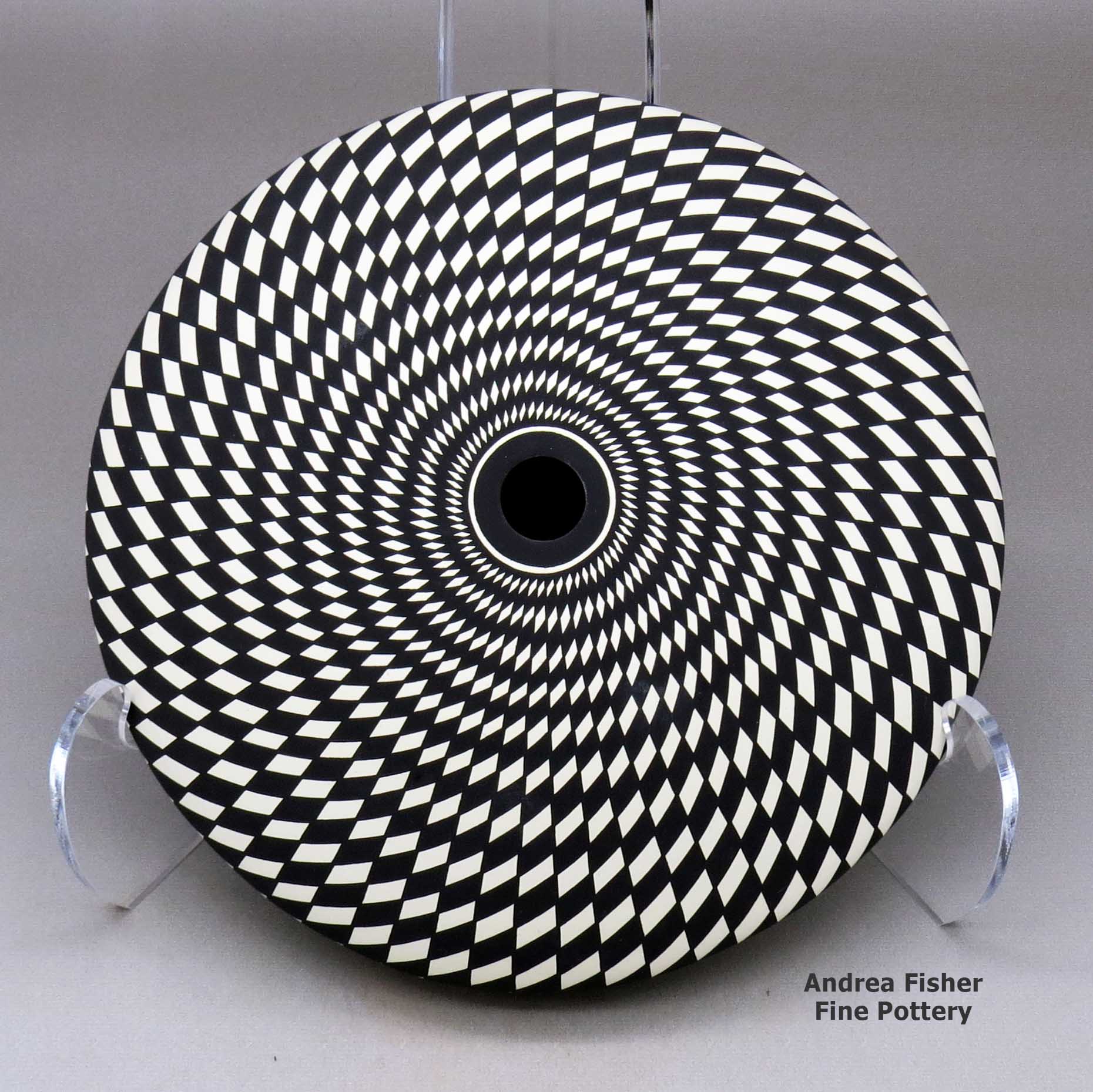 Click or tap to see a larger view A black on white seed pot decorated with a spiraling checkerboard geometric design made by Robert Kasero Sr of Laguna
