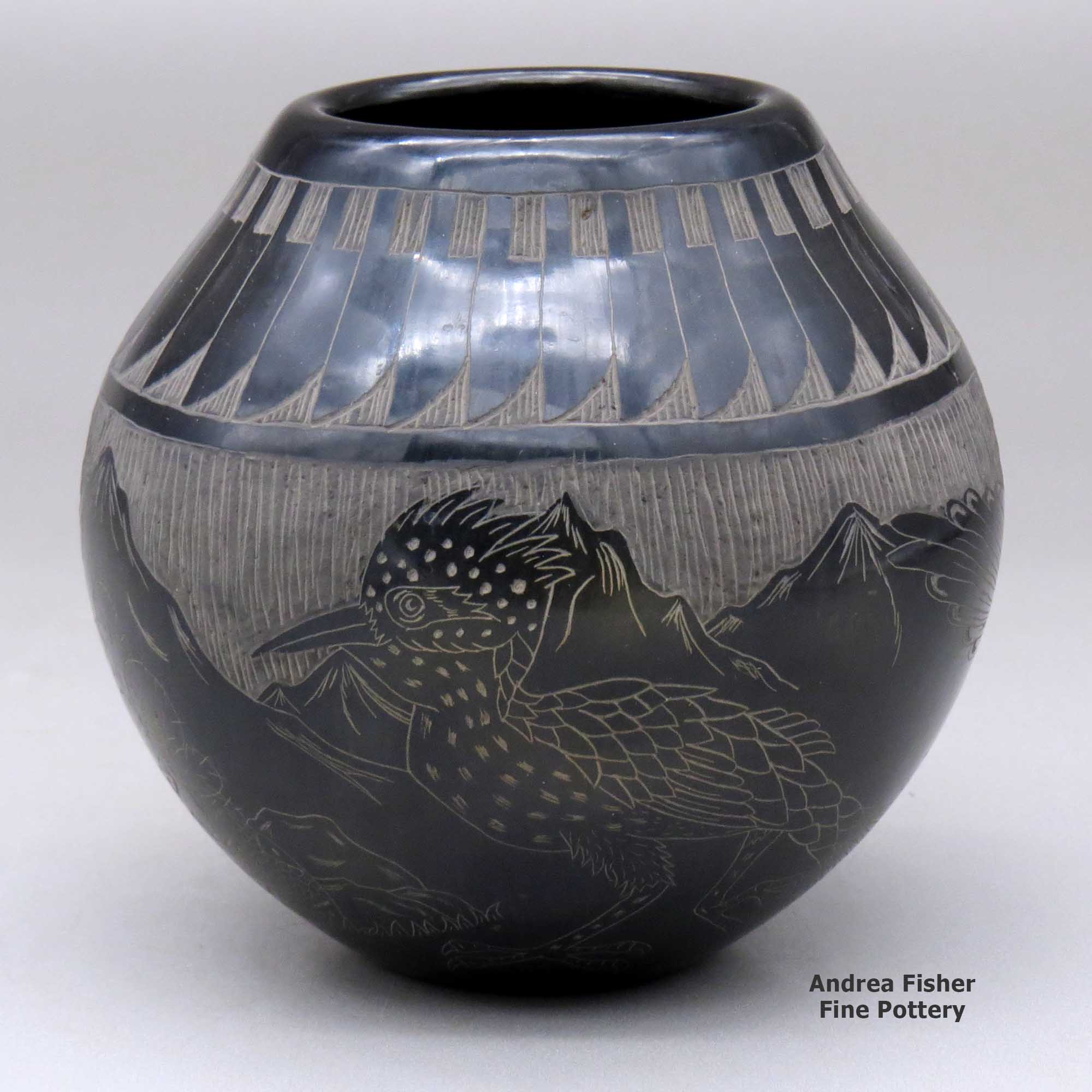 Click or tap to see a larger view A black jar decorated with a sgraffito feather, roadrunner, serpent and nature design made by Melvin Moquino of Santa Clara