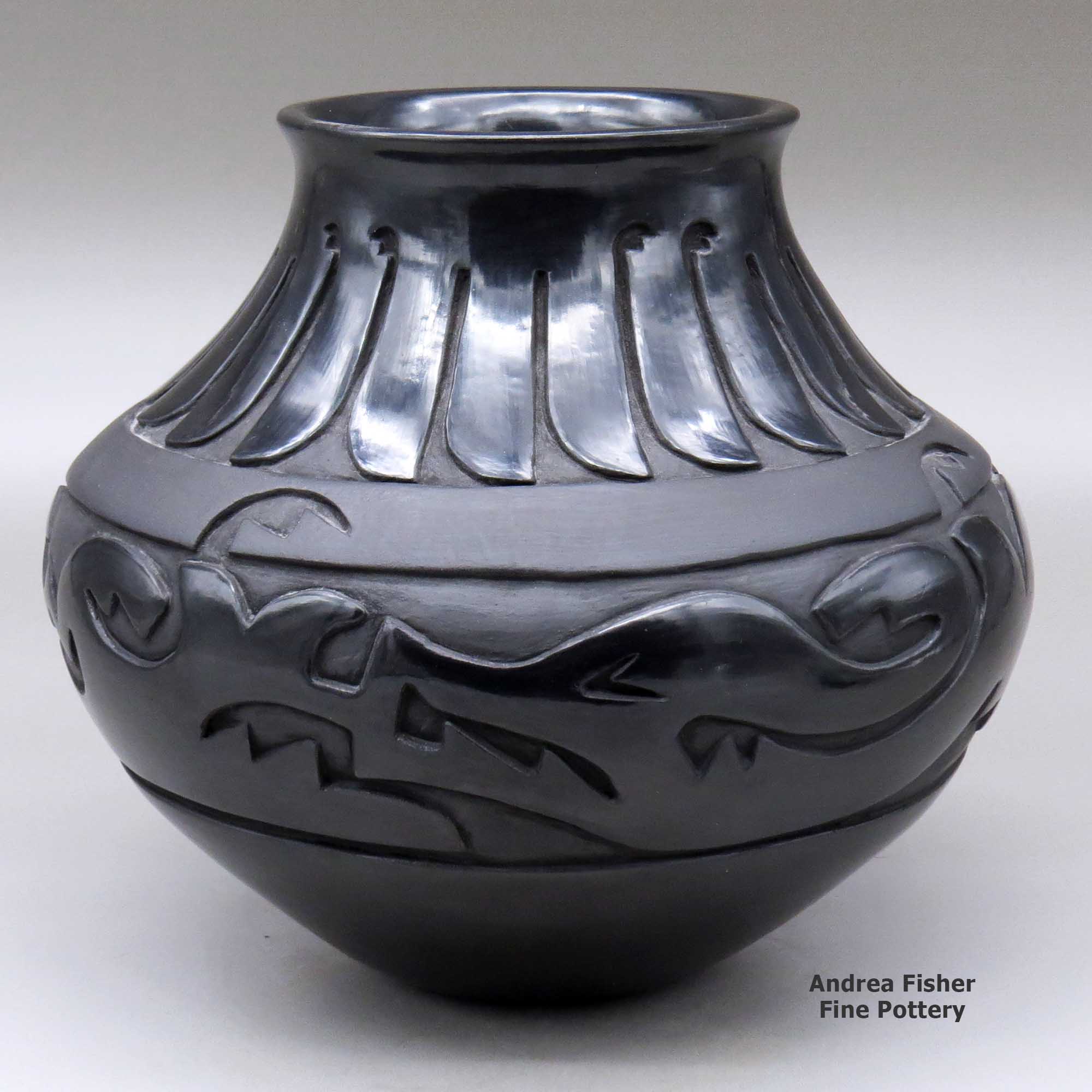 Click or tap to see a larger view A black jar with a flared rim and decorated with a carved avanyu design separated from a carved feather design by a carved band of matte black geometric design made by Sharon Naranjo Garcia of Santa Clara