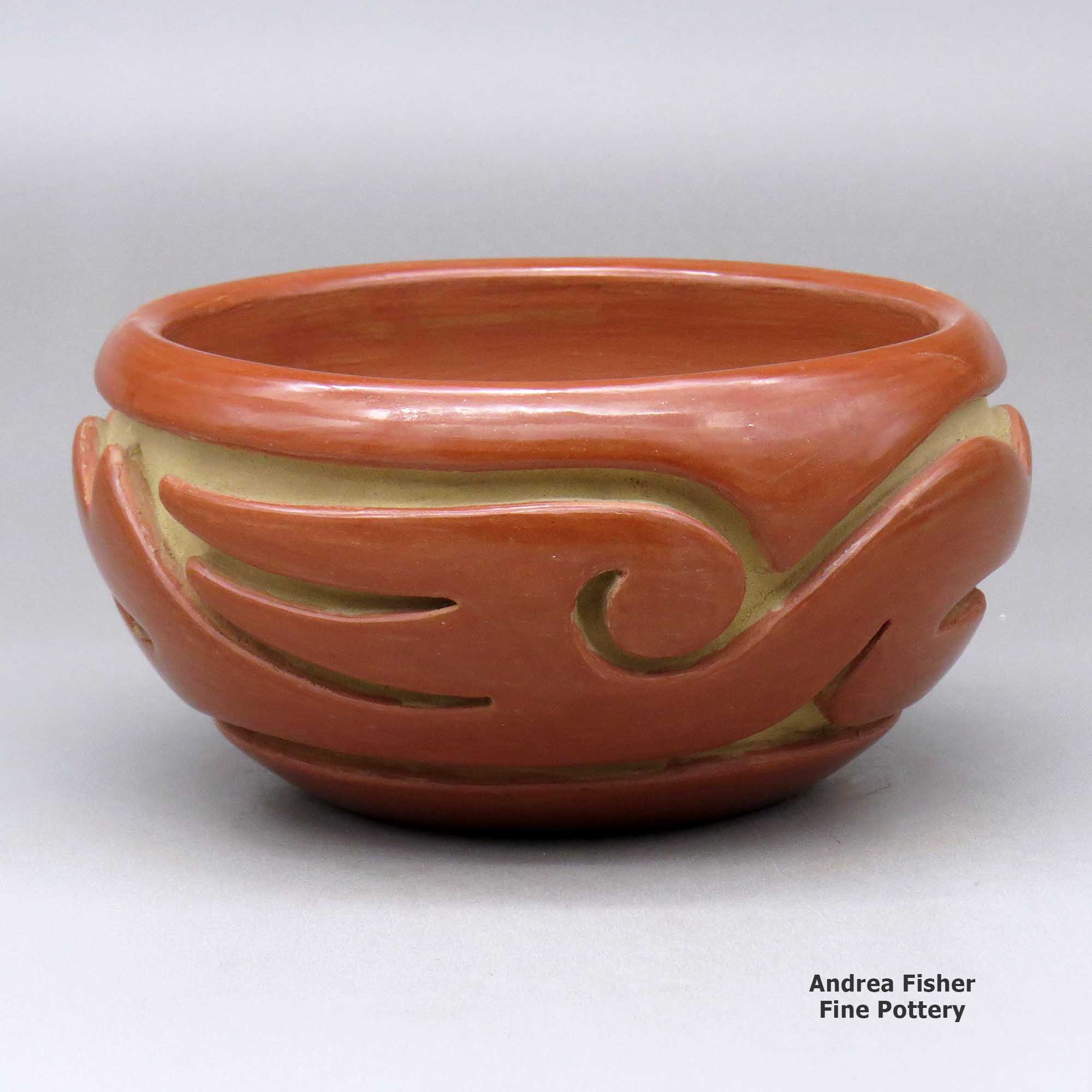 Click or tap to see a larger view A red bowl decorated with a stylized avanyu design carved around the body made by Teresita Naranjo of Santa Clara