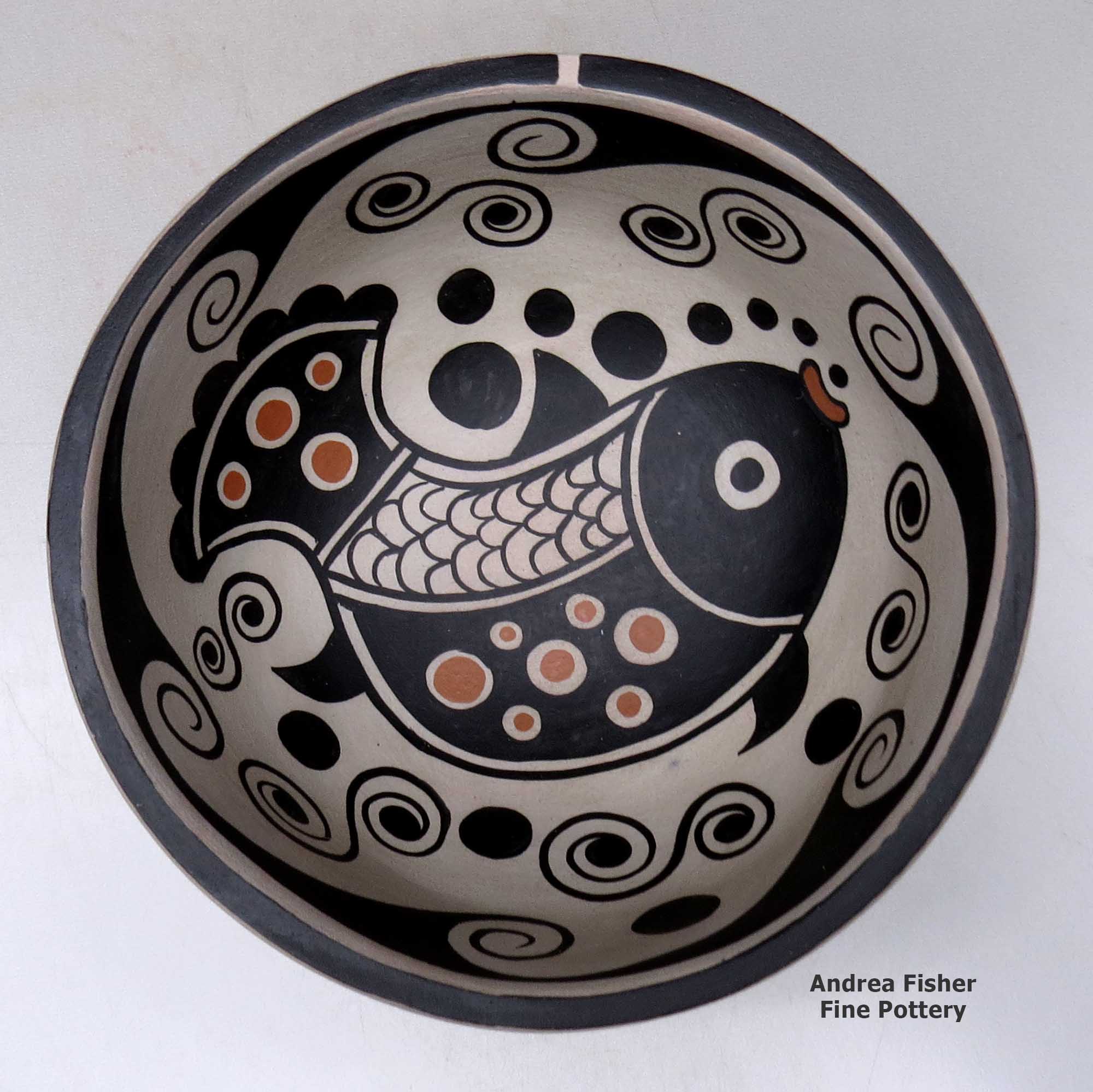 A polychrome chili bowl decorated with a fish and water symbol design inside, and a water symbol design outside made by Thomas Tenorio of Santo Domingo