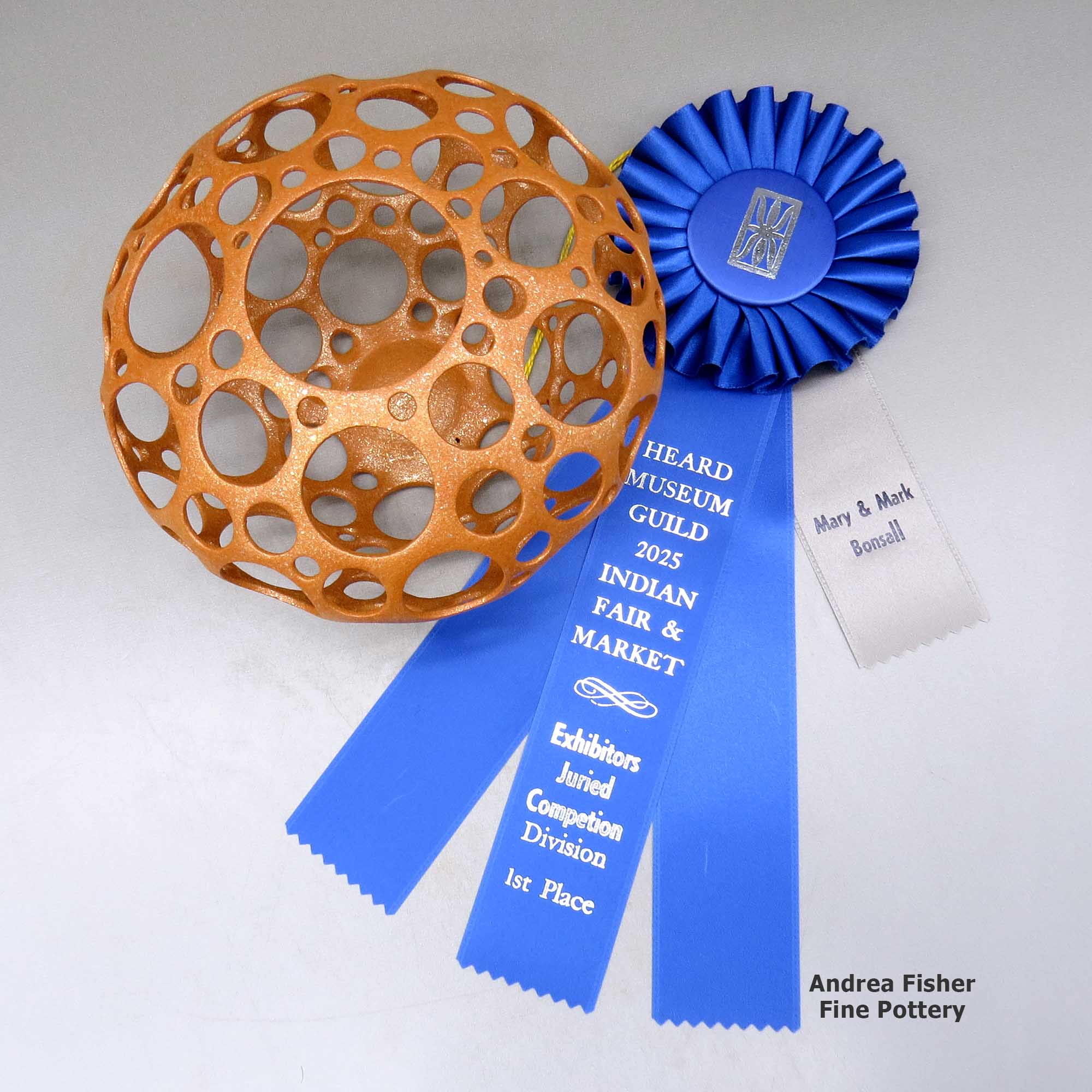 Click or tap to see a larger view A golden micaceous holey pot, First Prize ribbon from 2025 Heard Museum Indian Arts Fair and Market made by Hubert Candelario of San Felipe