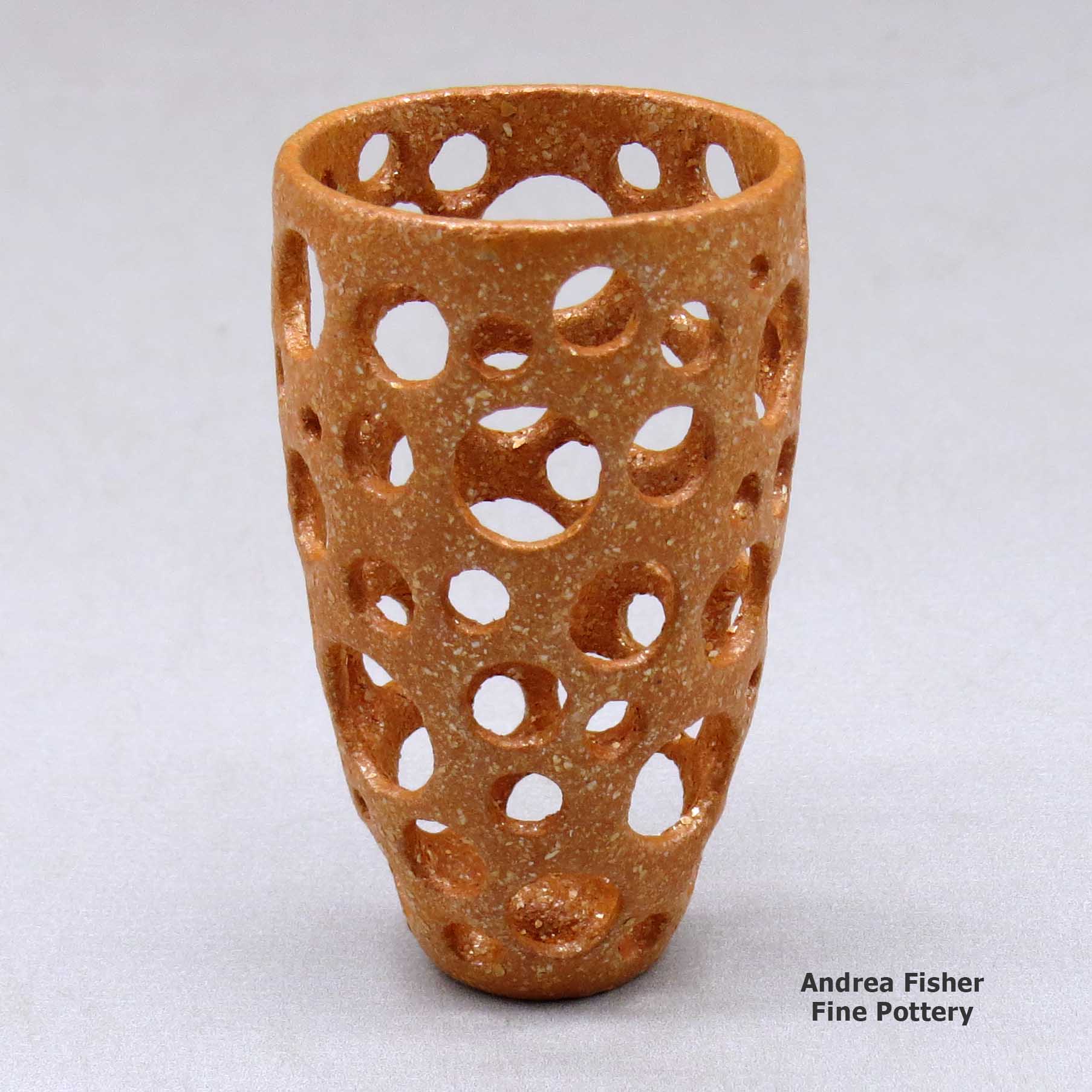 Click or tap to see a larger view A small golden micaceous holey cylinder made by Hubert Candelario of San Felipe