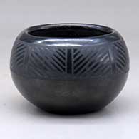 A small black on black bowl decorated with an eight panel geometric design taken from ancient rock art
 by Margaret Lou Gutierrez of San Ildefonso