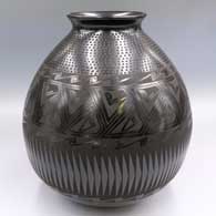 A glossy black-on-black jar with a flared rim, bands of geometric design around the shoulder and a band of corrugation below the neck
 by Armando Silveira of Mata Ortiz and Casas Grandes