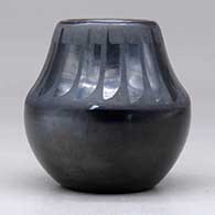 A small black on black jar decorated with a band of feathers design above the shoulder, click or tap to see a larger version