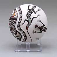 A polychrome seed pot decorated with a lizard head applique, a lightly carved line and a painted geometric design
 by Carolyn Concho of Acoma