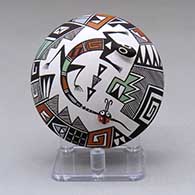 A polychrome seed pot decorated with lizard and lady bug appliques and painted with a fineline and geometric design
 by Sharon Lewis of Acoma