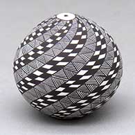 A miniature black on white seed pot decorated with a spiraling checkerboard and fineline design
 by Sharon Lewis of Acoma