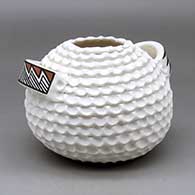 A corrugated white jar with geometric design on the two handles
 by Jackie Shutiva of Acoma
