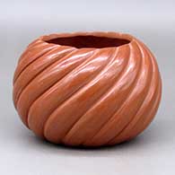 A red melon bowl with 16 repousse and carved ribs
 by Marcella Yepa of Jemez