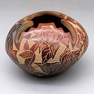 A red jar with an organic cutout in the top and a sgraffito and lightly carved butterfly, medallion, vine, flower and geometric design
 by Gwen Tafoya of Santa Clara