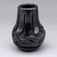 A small black jar carved around the body with an avanyu, scrolls and geometric design
 by Jennifer Naranjo of Santa Clara