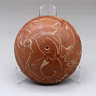 A red seed pot decorated with a sgraffito wildlife, nature and geometric design
 by Paul Naranjo of Santa Clara