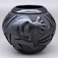 A black bowl carved around the body with a kokopelli and geometric design
 by Rosemary Lewis of Santa Clara