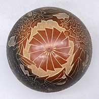 A black seed pot with a large sienna spot and decorated with a sgraffito hummingbird, flower, leaf, vine and geometric design, click or tap to see a larger version